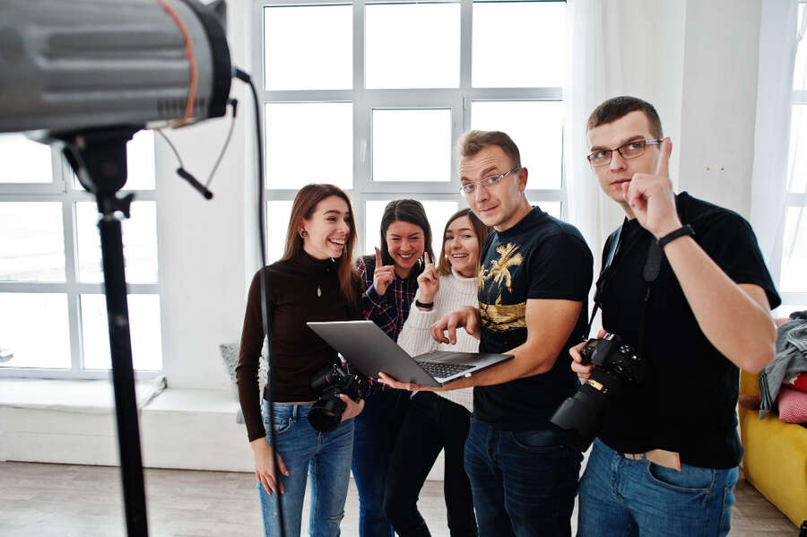 Eine Gruppe junger Leute diskutiert ein Script im Filmstudio.